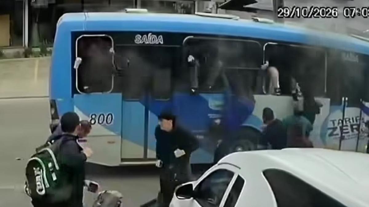 Passageiros tentando sair de ônibus em princípio de incêndio